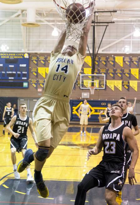 Boulder City senior guard Karson Bailey (14) dunks over Moapa Valley senior forward Derek Re ...