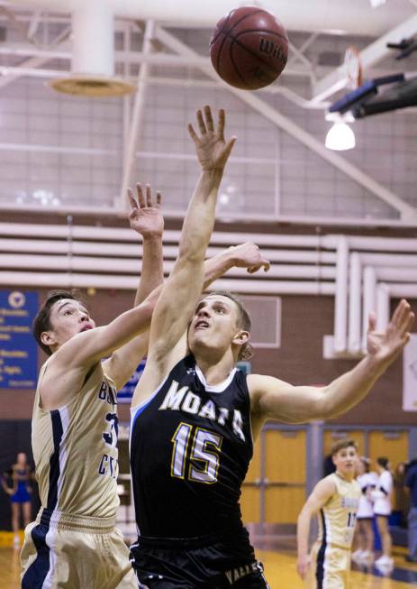 Moapa Valley senior forward Jessup Lake (15) drives past Boulder City sophomore forward Etha ...