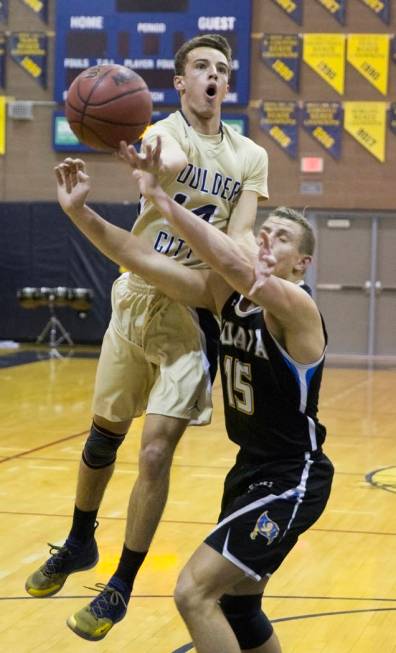 Boulder City senior guard Karson Bailey (14) drives past Moapa Valley senior forward Jessup ...