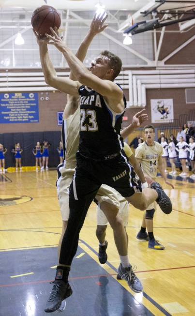 Moapa Valley senior forward Derek Reese (23) drives baseline past Boulder City sophomore for ...