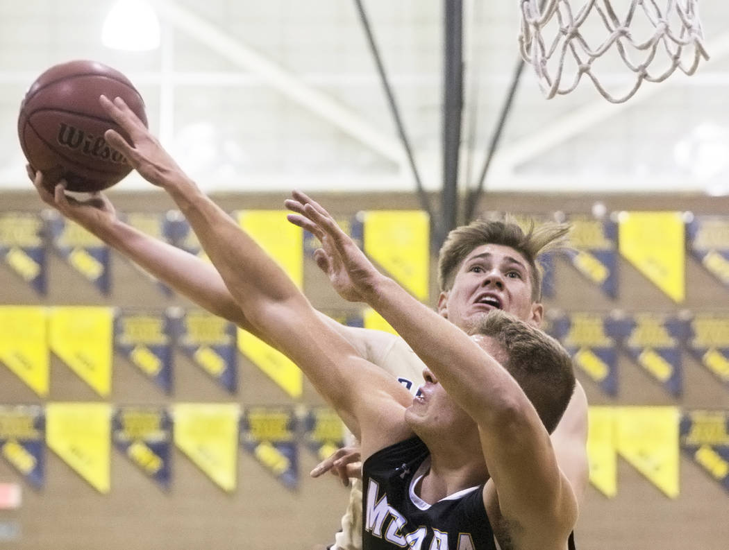 Boulder City junior guard Gavin Balistere (10) shoots over Moapa Valley senior forward Derek ...