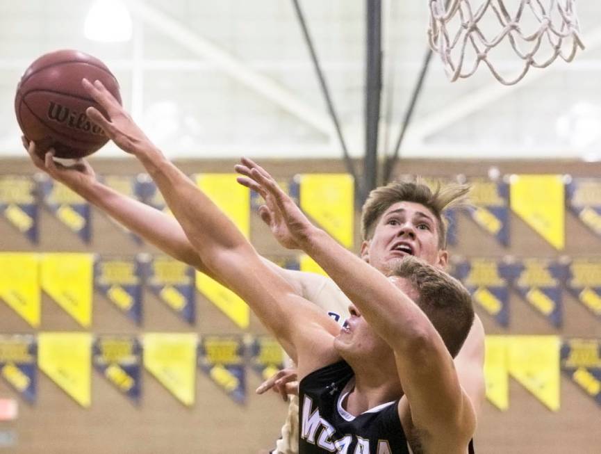 Boulder City junior guard Gavin Balistere (10) shoots over Moapa Valley senior forward Derek ...