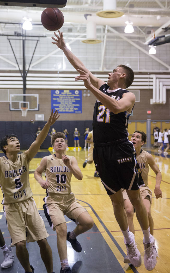 Moapa Valley senior center Josh Cox (21) drives baseline past Boulder City junior guard Gavi ...