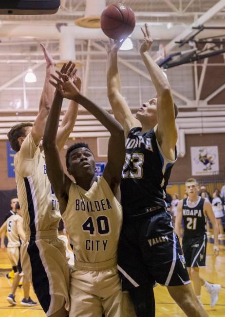 Moapa Valley senior forward Derek Reese (23) fights for a rebound with Boulder City junior f ...