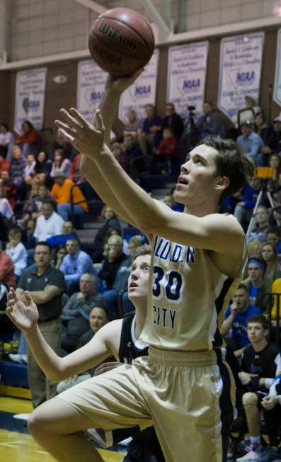 Boulder City sophomore forward Ethan Speaker (30) drives baseline past Moapa Valley sophomor ...