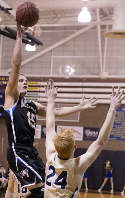 Moapa Valley senior forward Jessup Lake (15) shoots over Boulder City sophomore guard Matt M ...