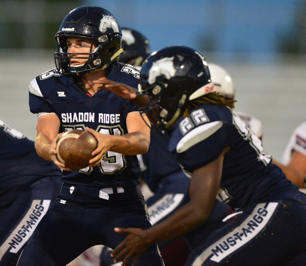 Shadow Ridge quarterback Kody Presser (33) hands the ball off to running back Anthony Wheato ...