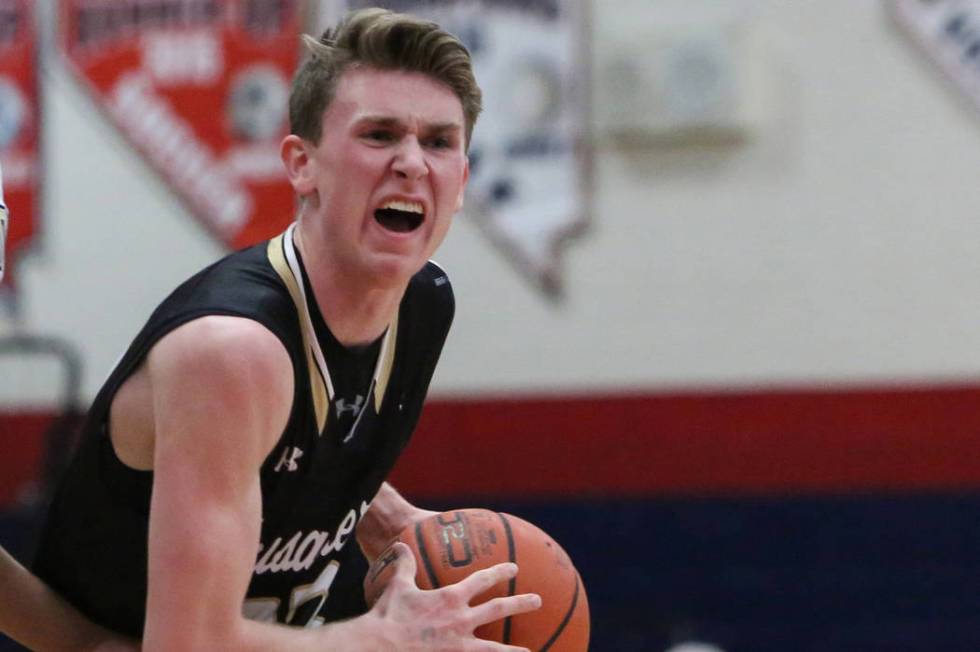 Faith Lutheran’s Brevin Walter (23) looks to pass the ball while under pressure from R ...