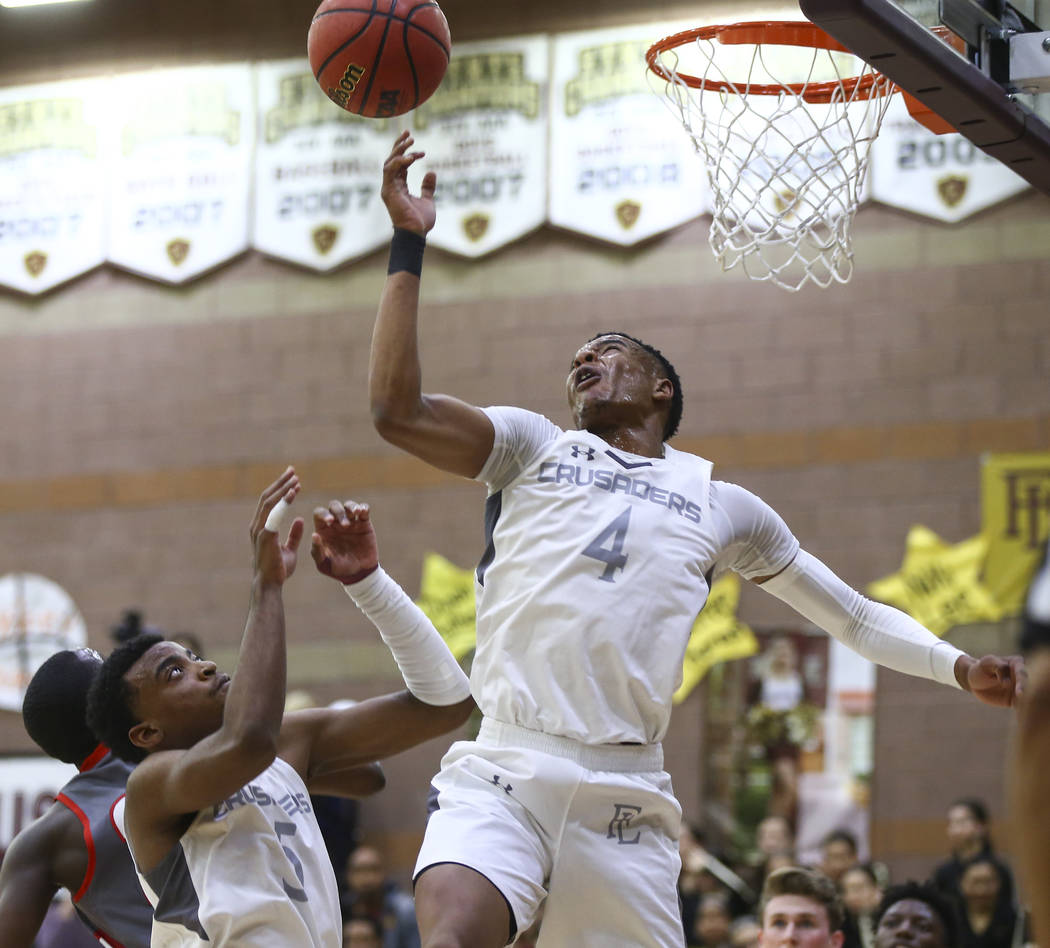 Faith Lutheran’s Sedrick Hammond (4) and Azavier Johnson (5) go up for a rebound durin ...