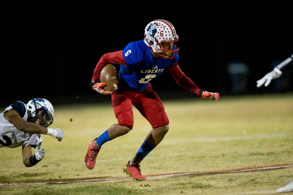 Liberty’s Cervontes White (6) runs the ball against Foothill in their football game at ...