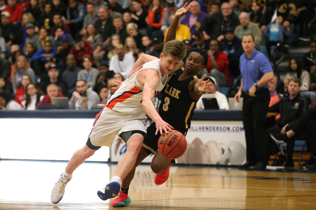 Bishop Gorman’s Noah Taitz (20) drives the ball to the hoop under pressure from Clark& ...