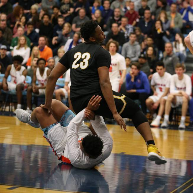 Clark’s Antwon Jackson (23) falls over Bishop Gorman’s Max Allen (12) in the Des ...