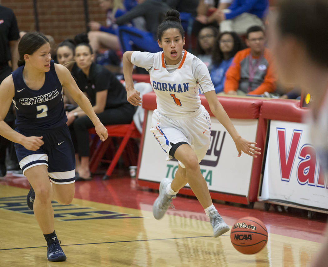 Bishop Gorman senior Caira Young (1) pushes the ball up court past Centennial senior Melanie ...