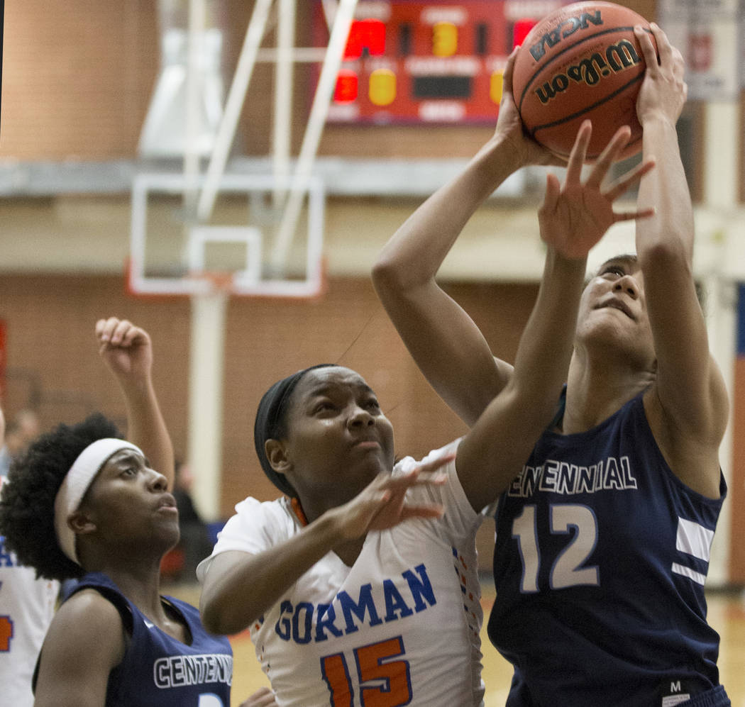 Centennial junior Aishah Brown (12) grabs a rebound over Bishop Gorman freshman Asya Bey (15 ...