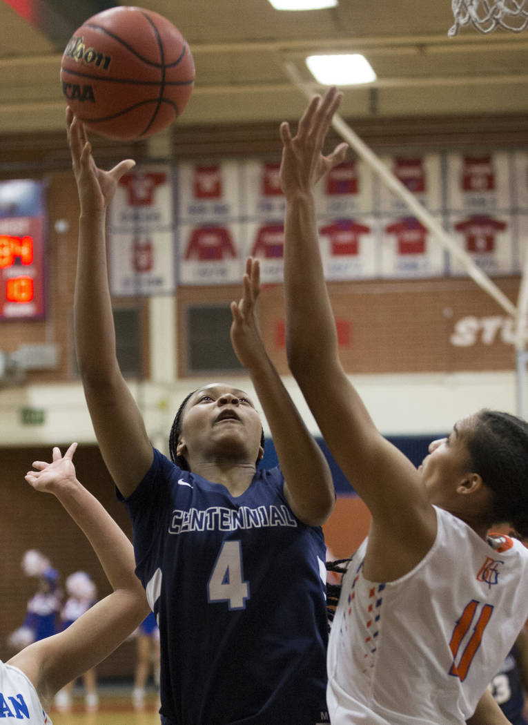 Centennial sophomore Taylor Bigby (4) drives past Bishop Gorman senior Olivia Smith (11) and ...