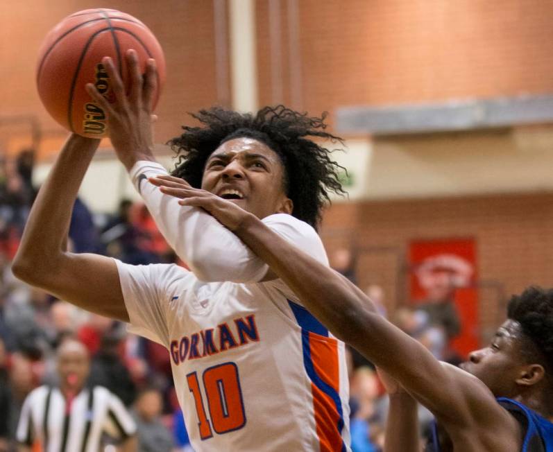 Bishop Gorman sophomore guard Zaon Collins (10) drives past Desert Pines sophomore Semaj Thr ...