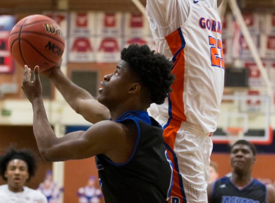 Desert Pines sophomore Semaj Threats (1) goes baseline past Bishop Gorman junior forward Mwa ...