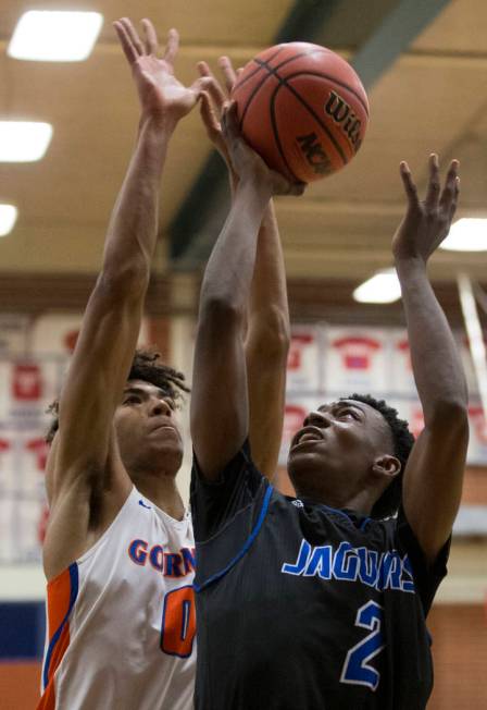 Desert Pines sophomore Dayshawn Wiley (2) grabs a rebound over Bishop Gorman junior forward ...