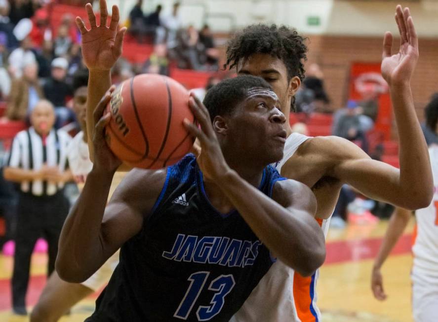 Desert Pines junior Darnell Washington (13) drives baseline past Bishop Gorman junior forwar ...