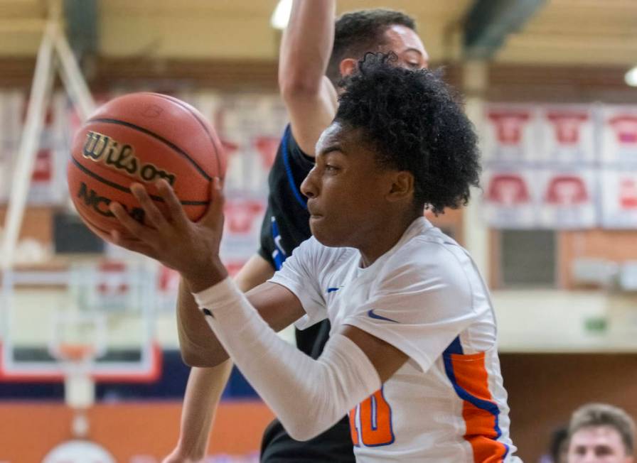 Bishop Gorman sophomore guard Zaon Collins (10) drives baseline past Desert Pines sophomore ...