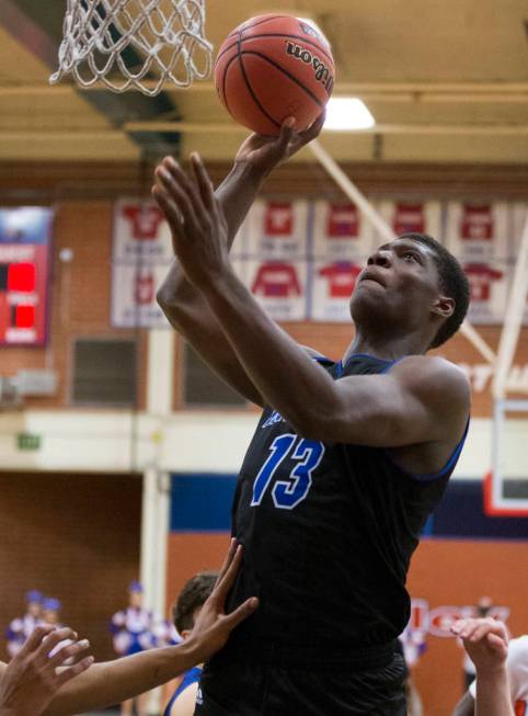 Desert Pines junior Darnell Washington (13) shoots a jump hook over Bishop Gorman defenders ...