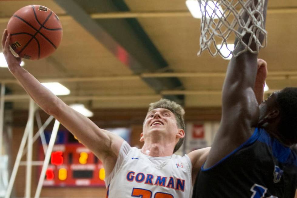 Bishop Gorman senior guard Noah Taitz (20) slices to the rim over Desert Pines junior Darnel ...