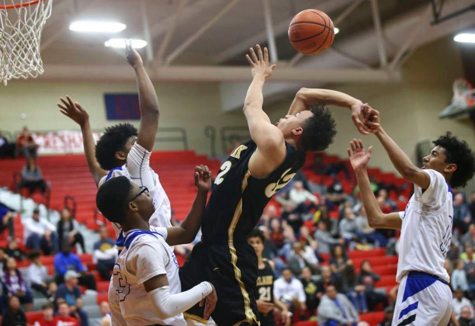 Clark’s Ian Alexander (32) gets fouled by Desert Pines’ Milos Uzan (12) during t ...