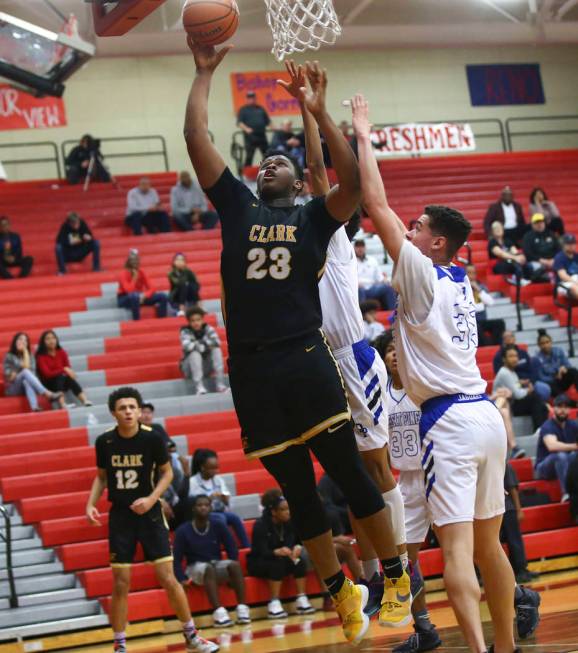 Clark’s Antwon Jackson (23) shoots past Desert Pines’ Jamir Stephens (33) during ...