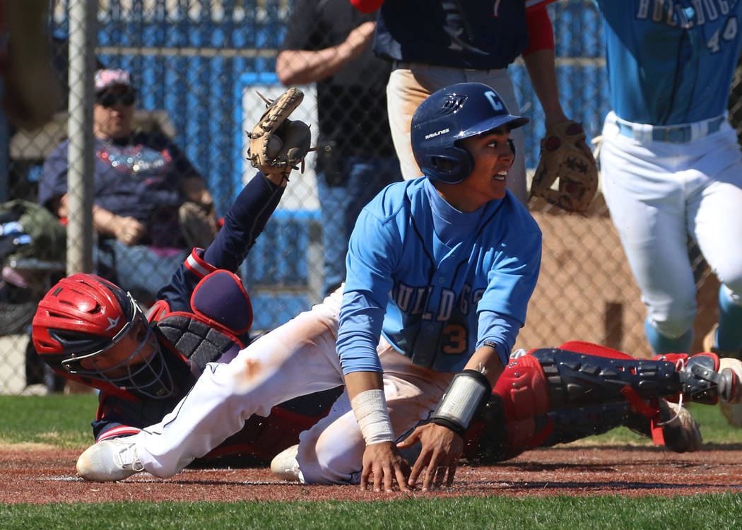 Centennial’s Anthony Martinez, center, avoids a tag from Liberty’s catcher James ...