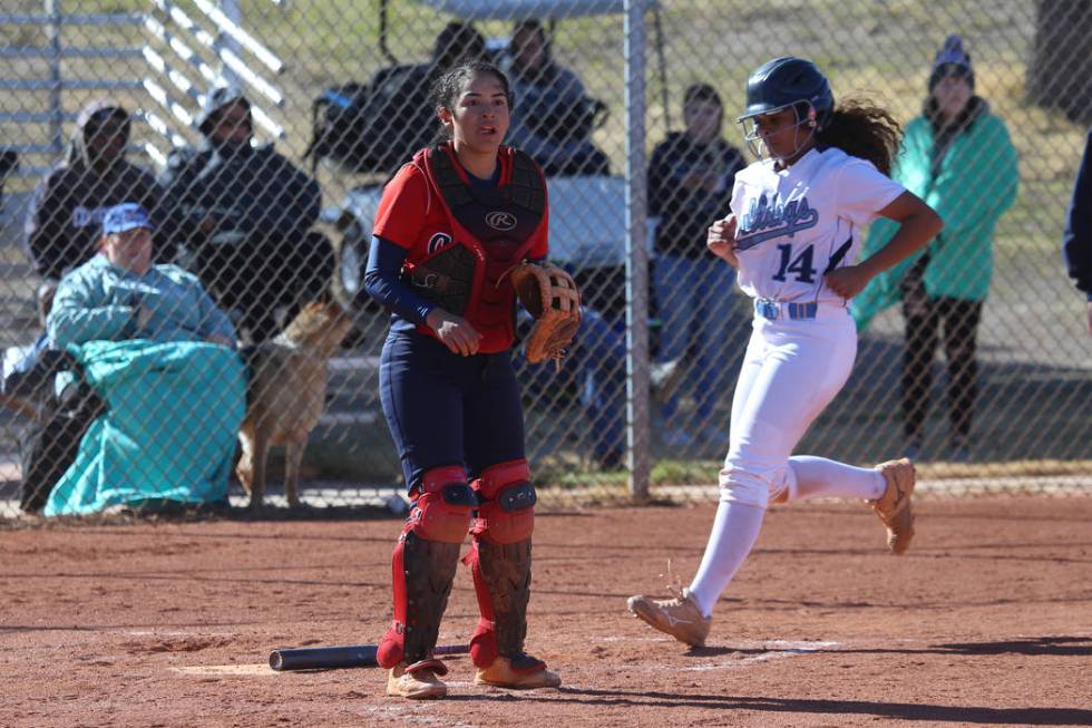 Centennial’s Maddie Kallfelz (14) runs home for a run after a hit by Tatum Huntly (9) ...