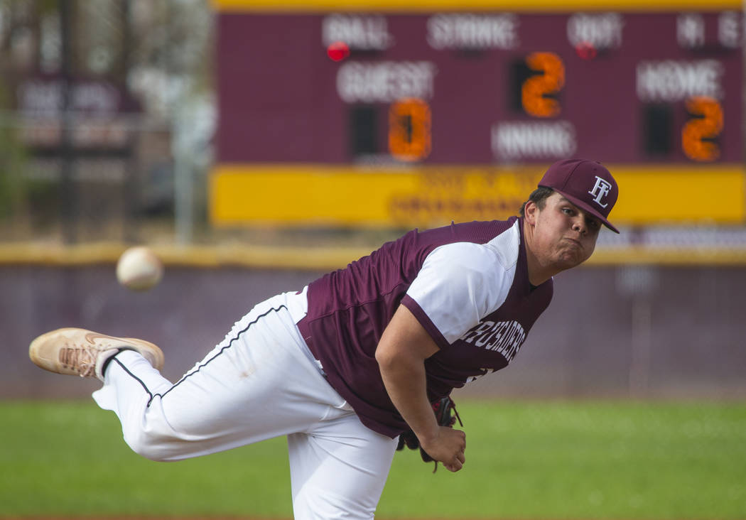 Faith Lutheran’s pitcher Christian Dijkman (21) sends another ball towards the plate v ...