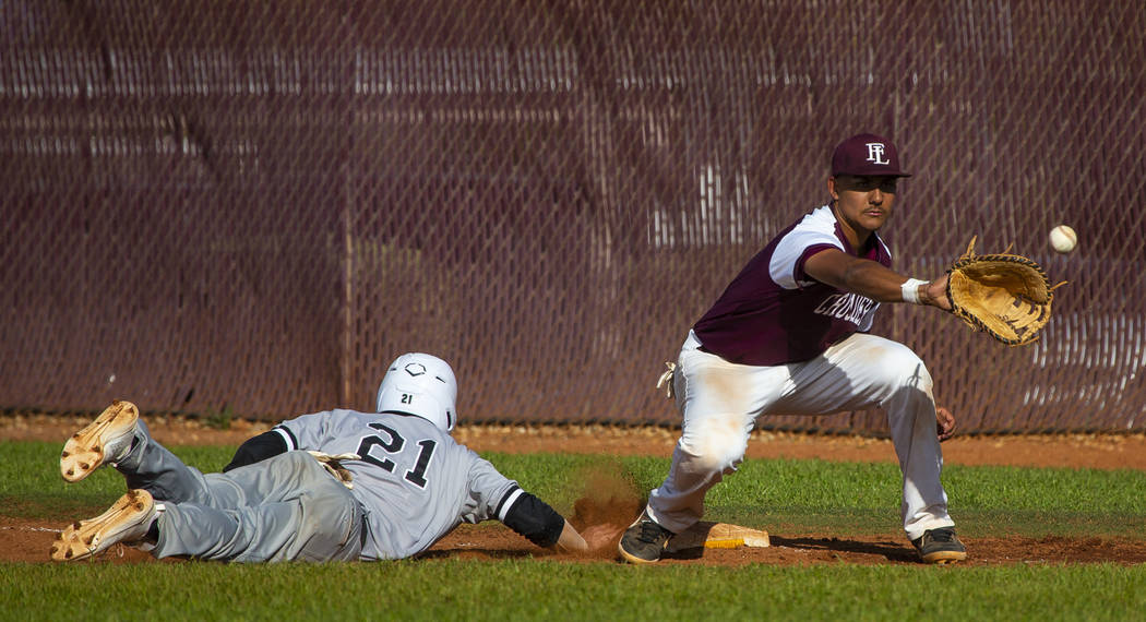 Palo Verde’s Josiah Cromwick (21) dives back to first base ahead of a throw to Faith L ...