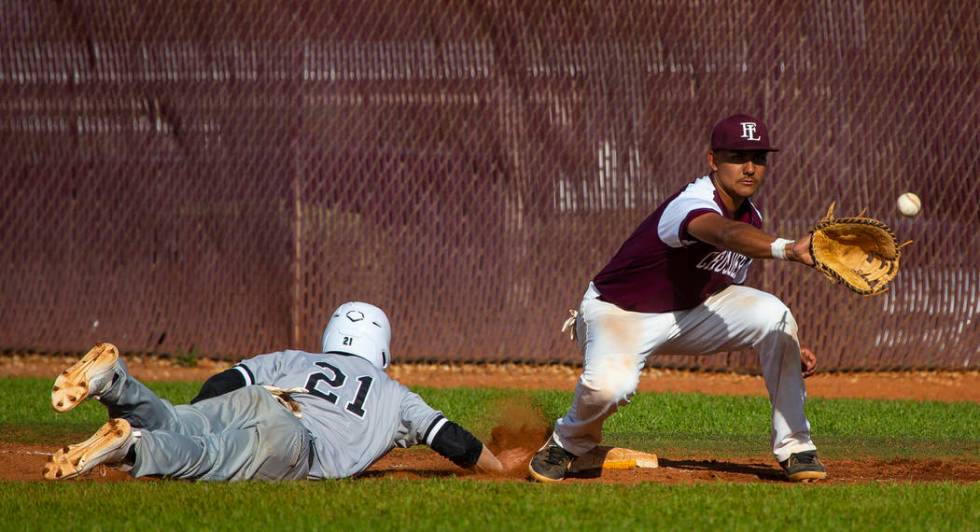 Palo Verde’s Josiah Cromwick (21) dives back to first base ahead of a throw to Faith L ...