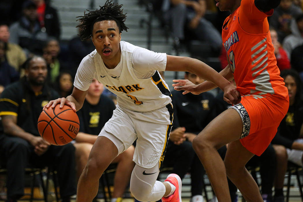 Clark’s Frankie Collins (1) drives past Bishop Gorman’s Zaon Collins (10) during ...