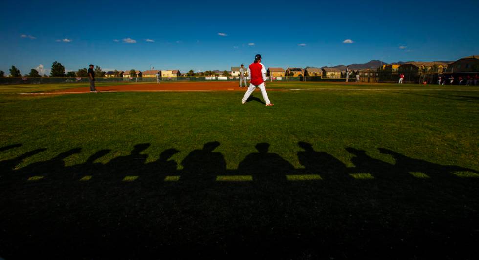 Spring Valley players are silhouetted behind Liberty head coach Rich Ebarb during the first ...