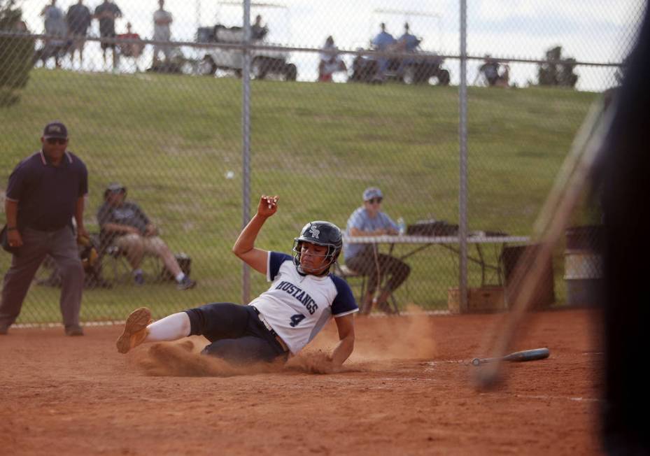 Shadow Ridge High School’s Shea Clements (4) slides to make home base against Centenni ...