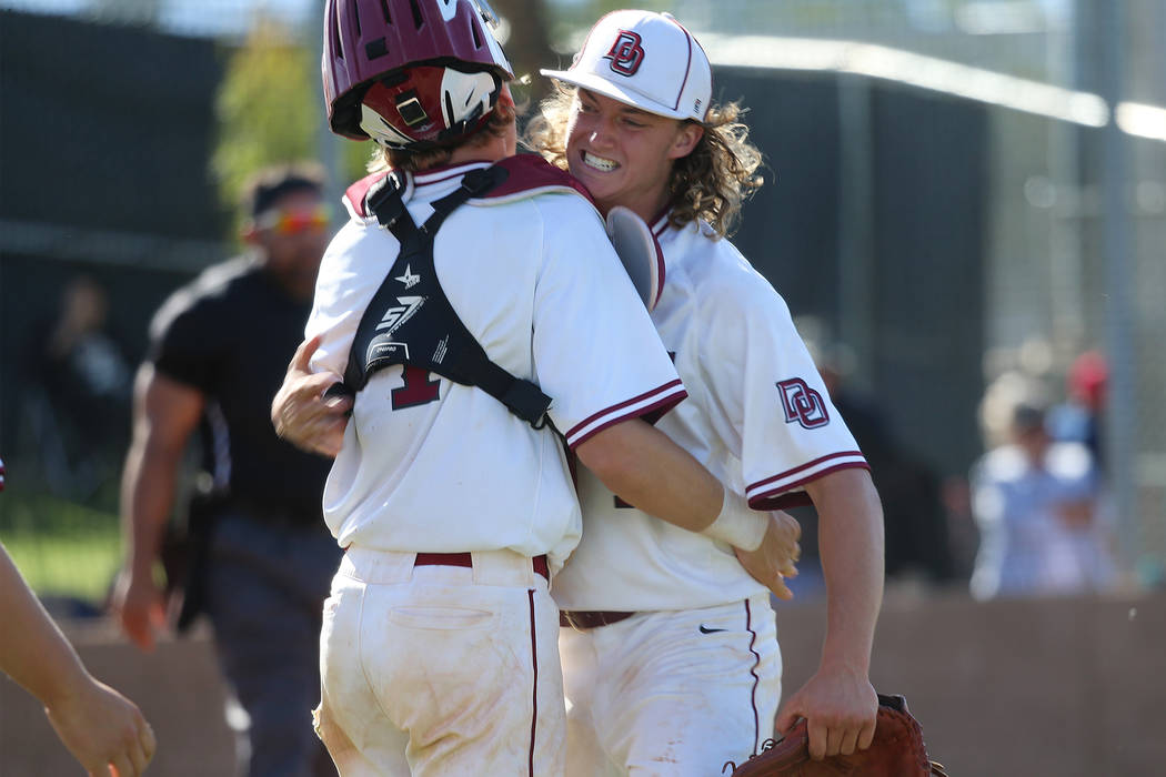 Desert Oasis’ pitcher Colby Smith (11), right, embraces catcher Parker Schmidt (4) aft ...