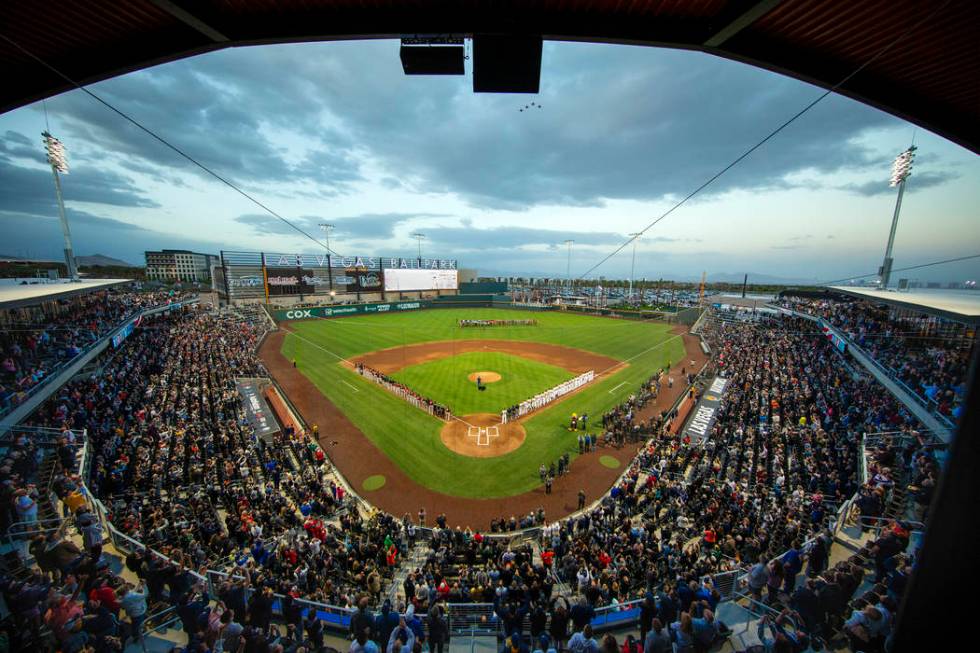 Four F-16 jets from Nellis Air Force Base fly over the ballpark with an American flag unfurl ...