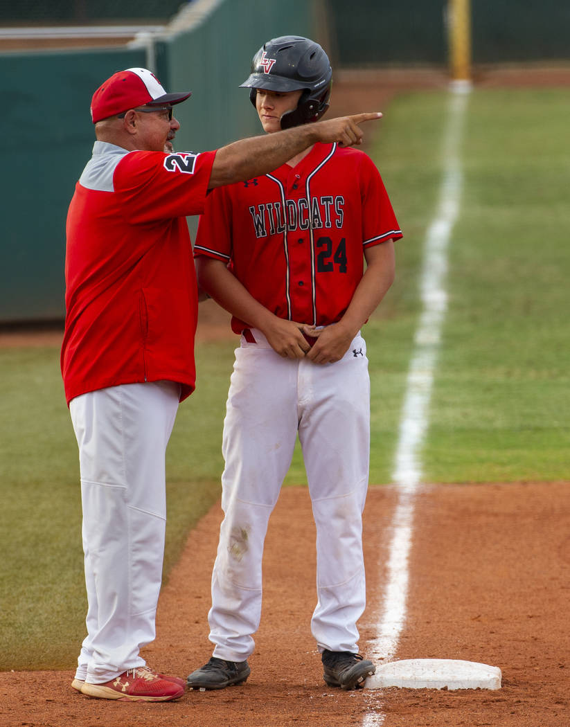 Las Vegas head coach Sam Thomas counsels his runner Brady O’jeda (24) at third base ve ...