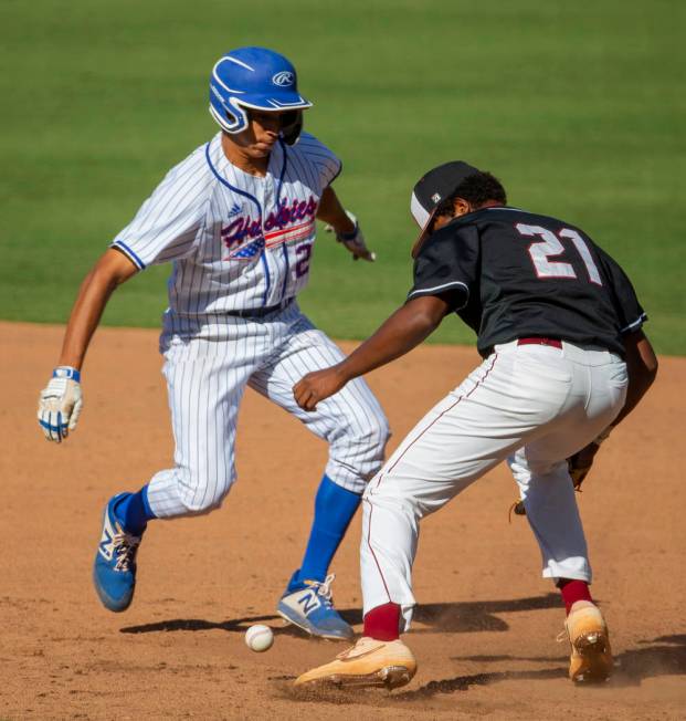 Reno’s Skylar Hales (24) scurries safely back to first base after a bad throw to Deser ...