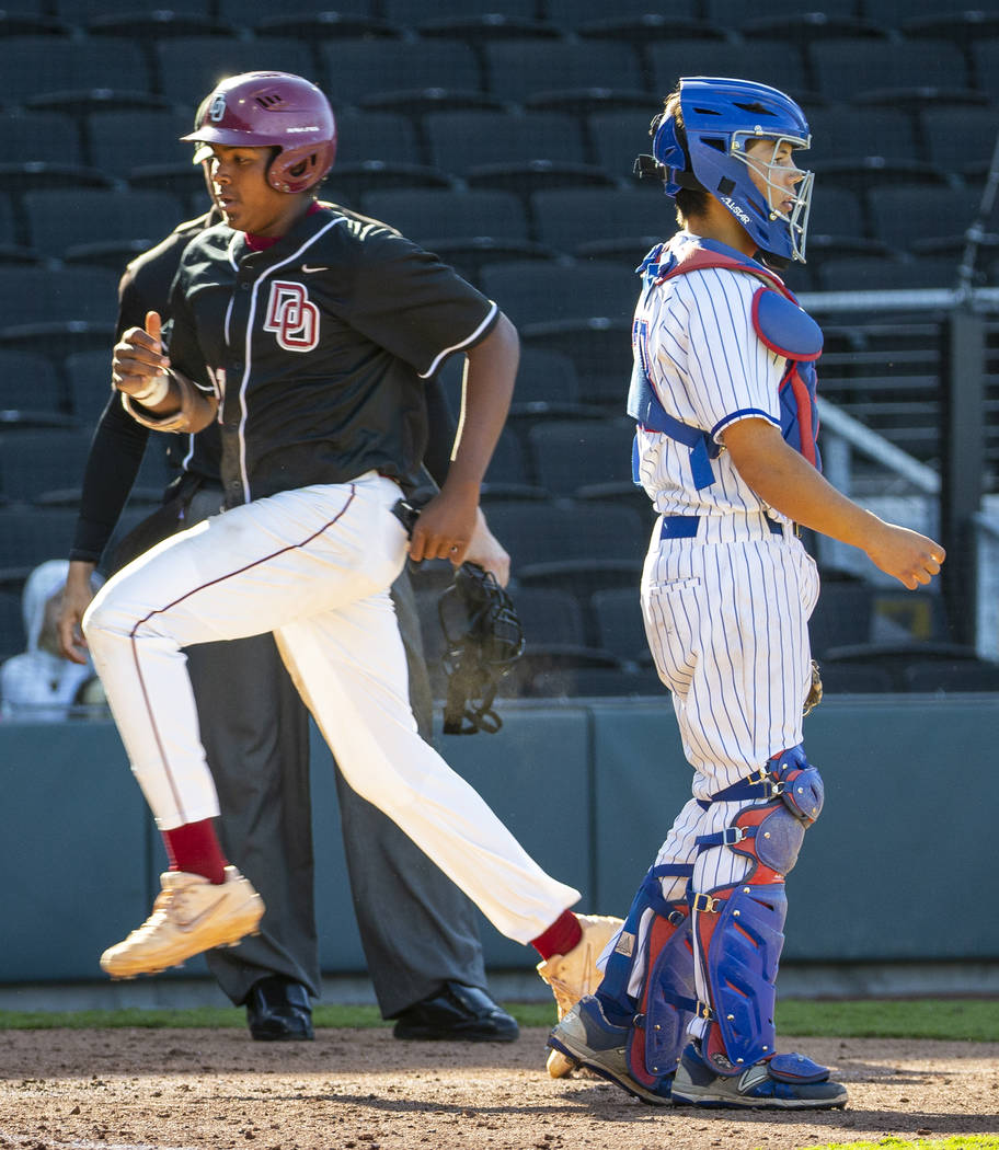 Desert Oasis’ Jacob Walsh (21) scores as Reno catcher Lane Oliphant (28) waits for the ...