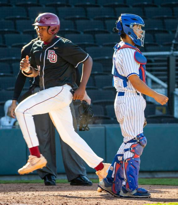 Desert Oasis’ Jacob Walsh (21) scores as Reno catcher Lane Oliphant (28) waits for the ...