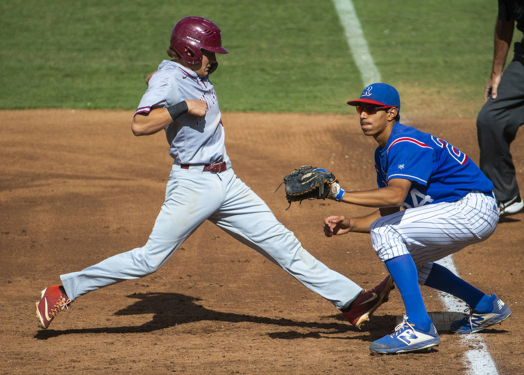 Desert Oasis runner Parker Schmidt (4) extends safely back to first base past Reno’s S ...