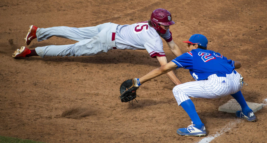 Desert Oasis runner Campbell Holt (15) dives safely back to first base past Reno’s Sky ...