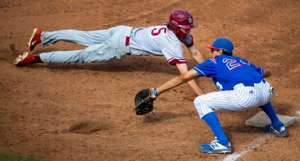 Desert Oasis runner Campbell Holt (15) dives safely back to first base past Reno’s Sky ...