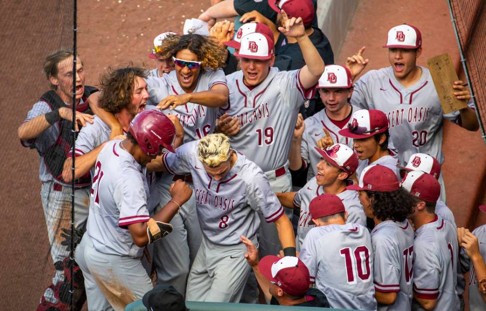 Desert Oasis teammates celebrate a run by Jacob Walsh (21) over Reno in the second inning du ...