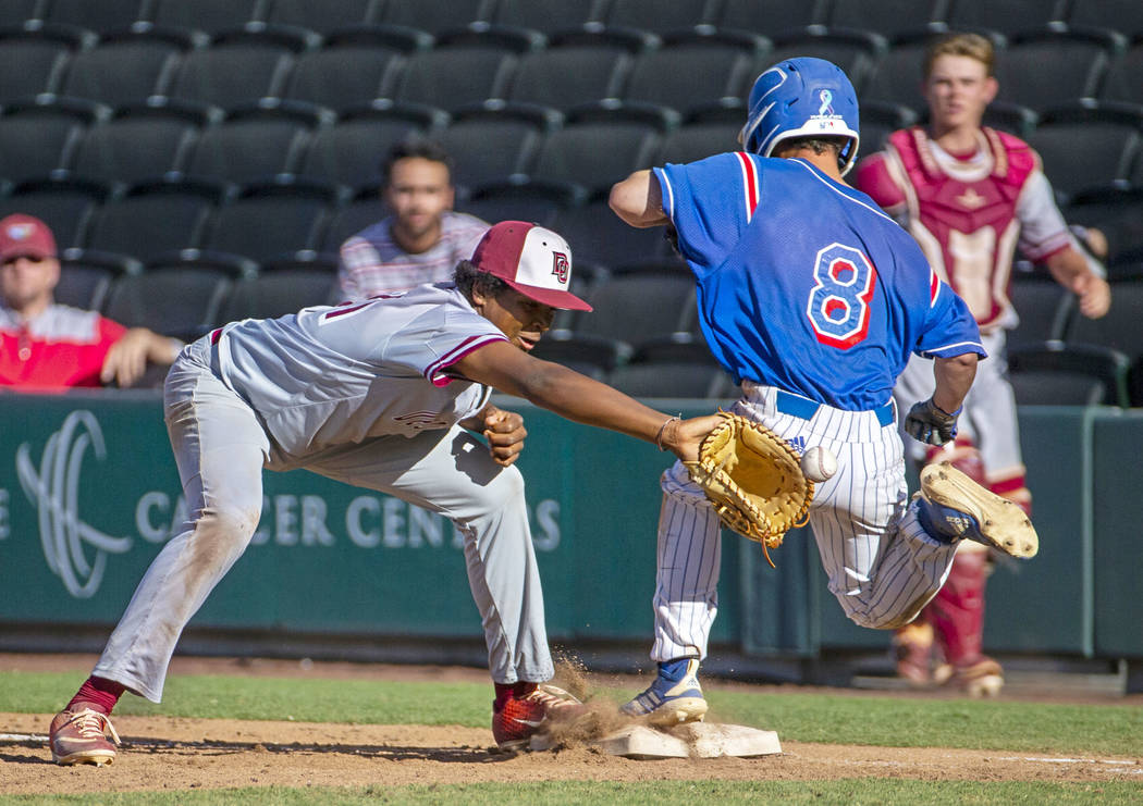 Desert Oasis’ Jacob Walsh (21) receives the ball late though Reno runner Gunner Goulds ...