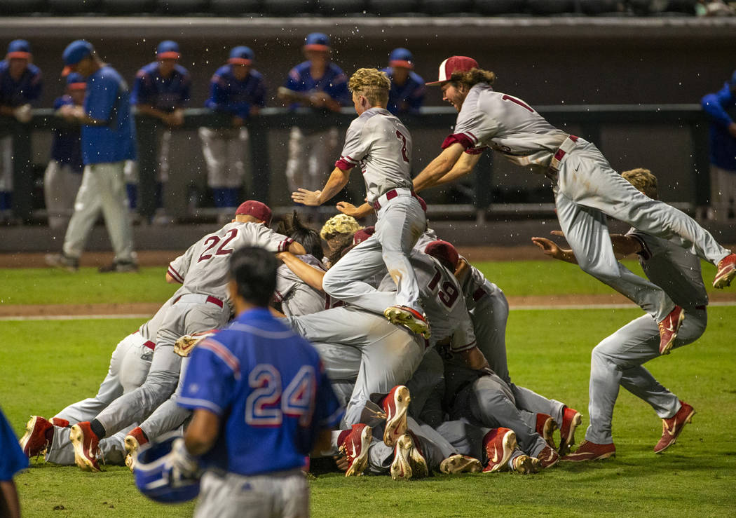 Desert Oasis players celebrate their win over Reno 9-1 during the tie-breaker game of their ...