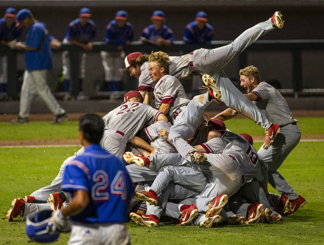 Desert Oasis players celebrate their win over Reno 9-1 during the tie-breaker game of their ...