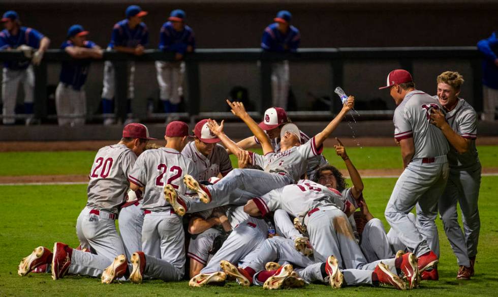 Desert Oasis players celebrate their win over Reno 9-1 during the tie-breaker game of their ...